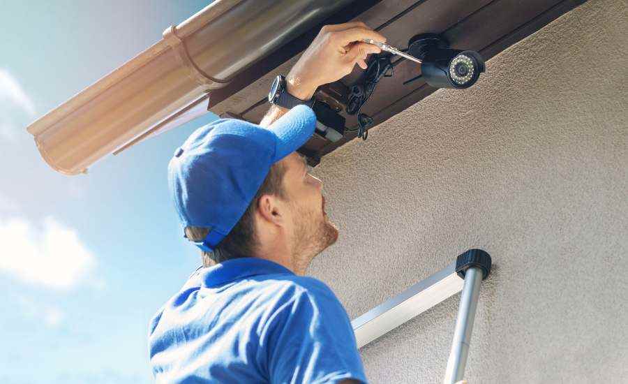 Funcionário instalando câmera de segurança residencial